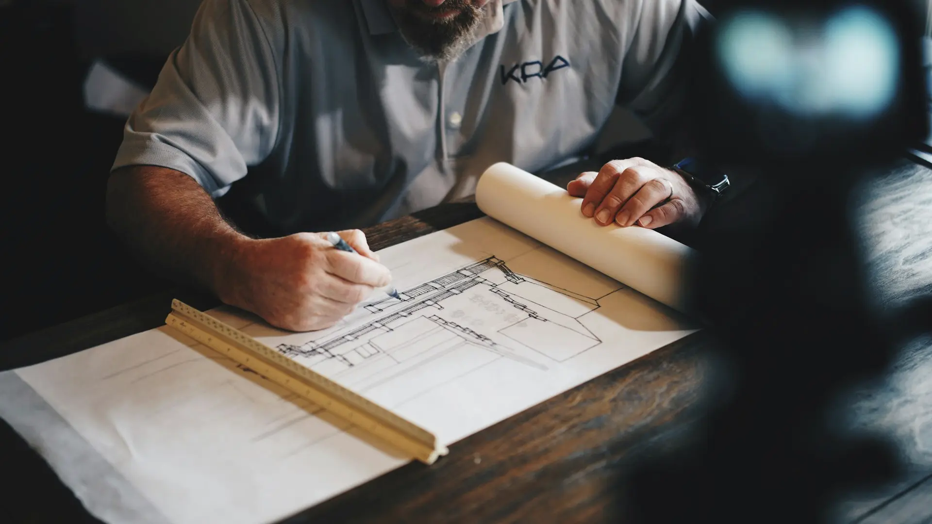 An architect working on a draft with a pencil and ruler
